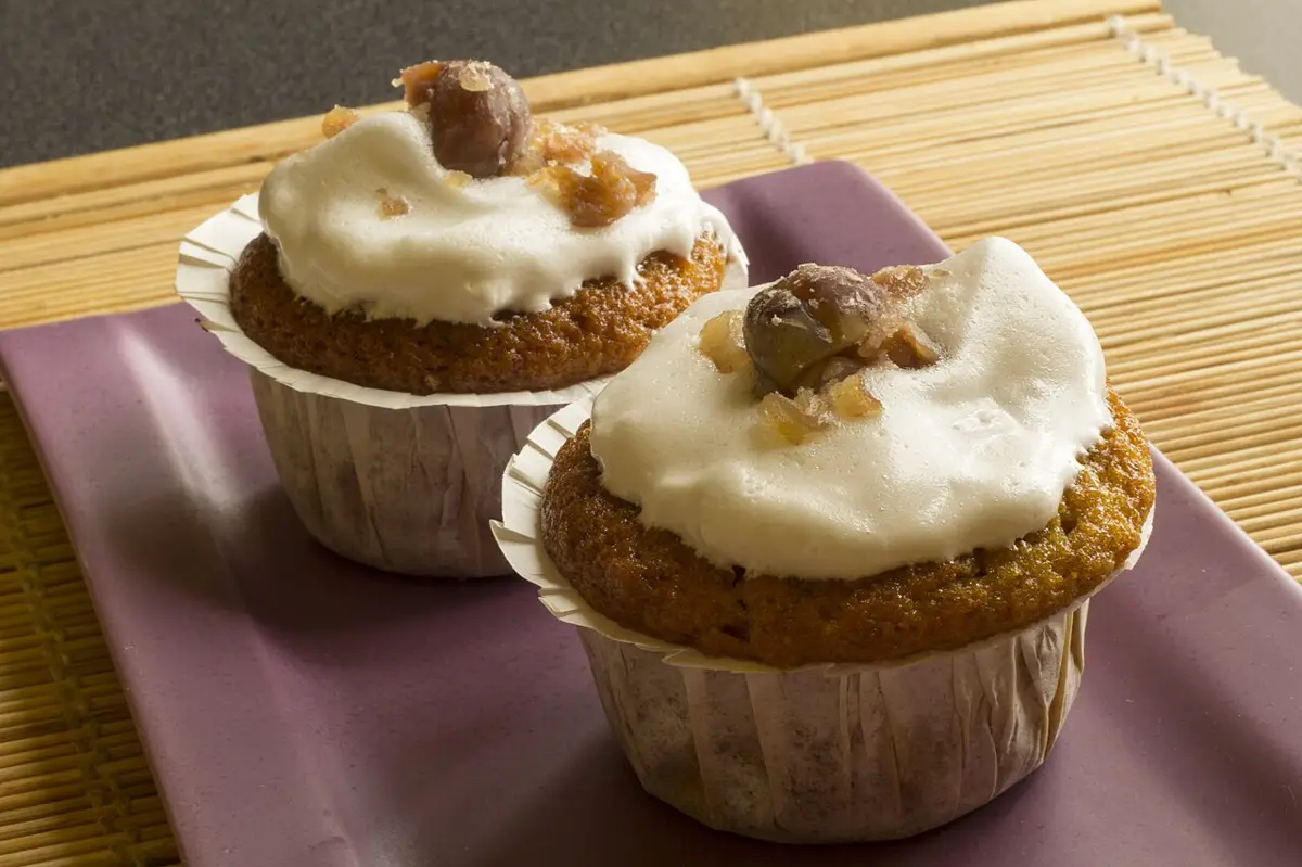 Two frosted pumpkin muffins on a plate (stock photo)